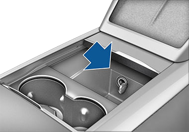 Center console with arm rest lifted, revealing power outlet in the compartment