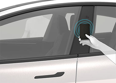 Image of a person touching the key card to the driver's side door pillar.